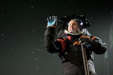 A man in a black and orange moon suit. 