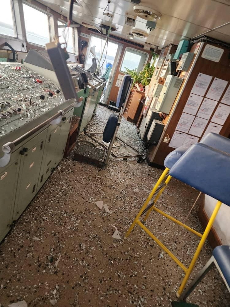 The interior of a ship cabin, with debris strewn across the floor.