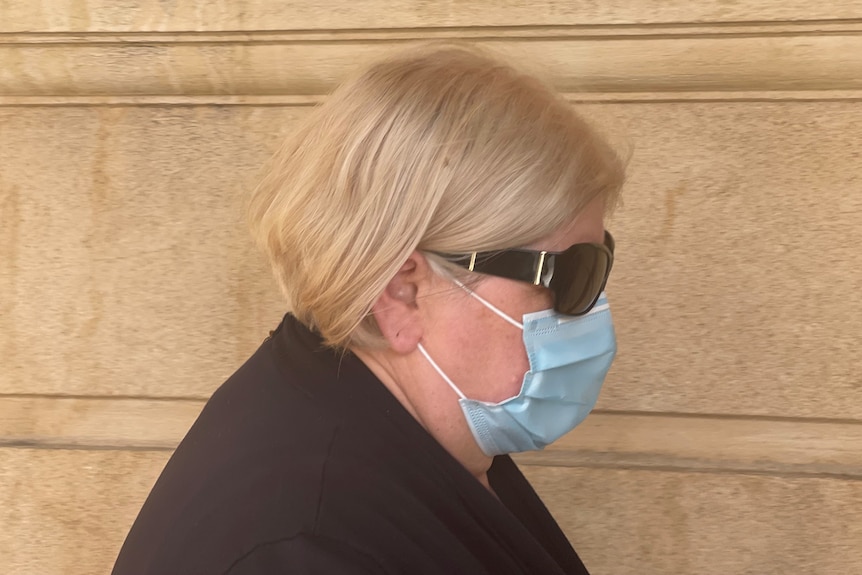 A woman wearing a face mask and sunglasses