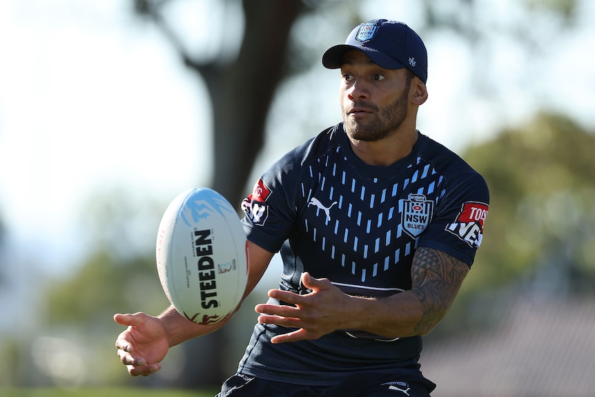 Apisai Koroisau passes the ball while wearing NSW training kit