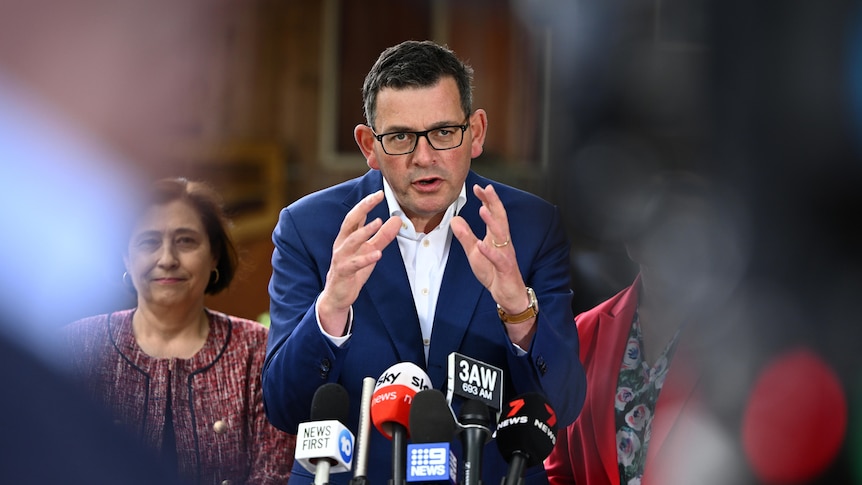 Daniel Andrews holds his hands out as he addresses a media conference.