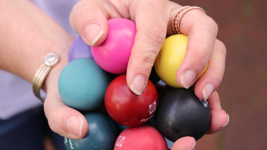 A close-up shot of minigolf balls held by Belinda August.