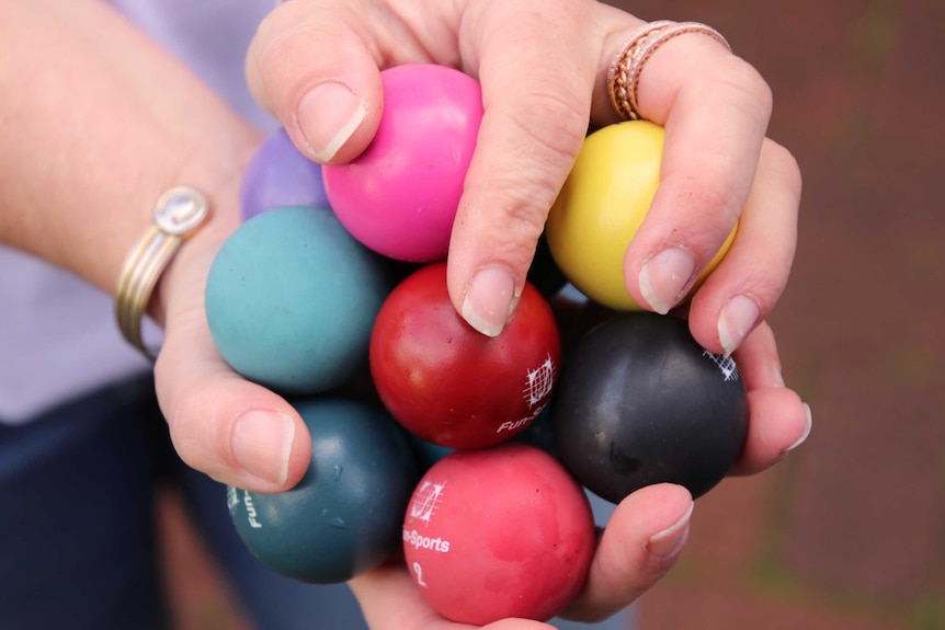 A close-up shot of minigolf balls held by Belinda August.