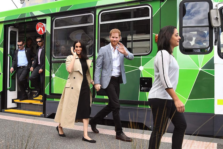 Britain's Prince Harry and Meghan, Duchess of Sussex wave to the well-wishers after taking a ride on a tram in Melbourne.