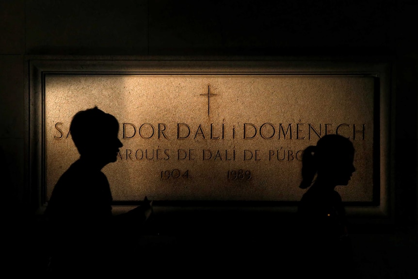 People walk past a stone of Salvador Dali's tomb inside the Teatre-Museu Dali.