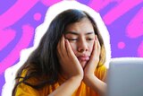 A girl looking bored at a computer surrounded by purple and pink graphics.