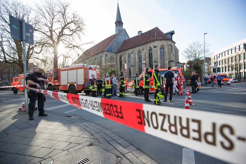 Policemen and firefighting trucks are seen on a street cordoned by police.