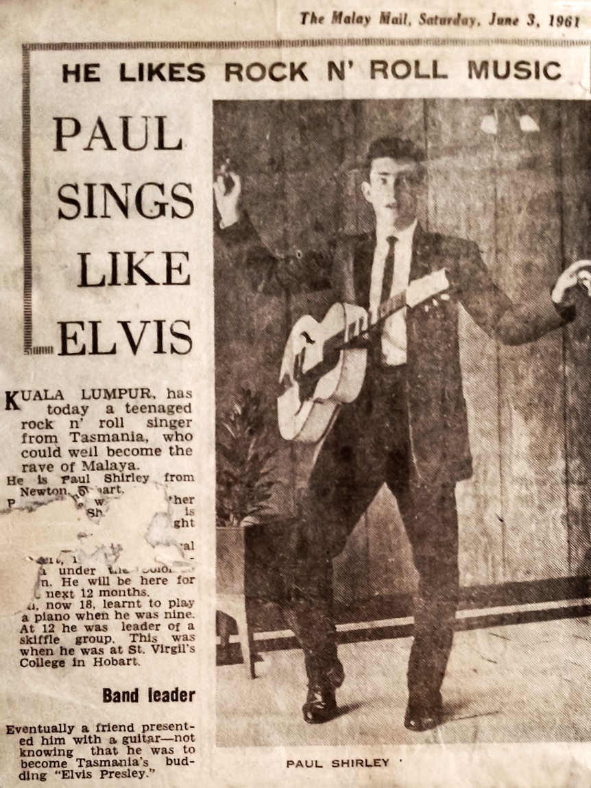 An old newspaper shows a man with a pompadour and a guitar with the words 'Paul sings like Elvis'