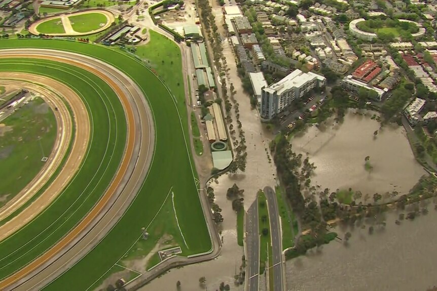 Aerial photo showing a dry racecourse next to flooding.