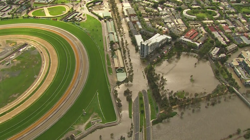 Aerial photo showing a dry racecourse next to flooding.