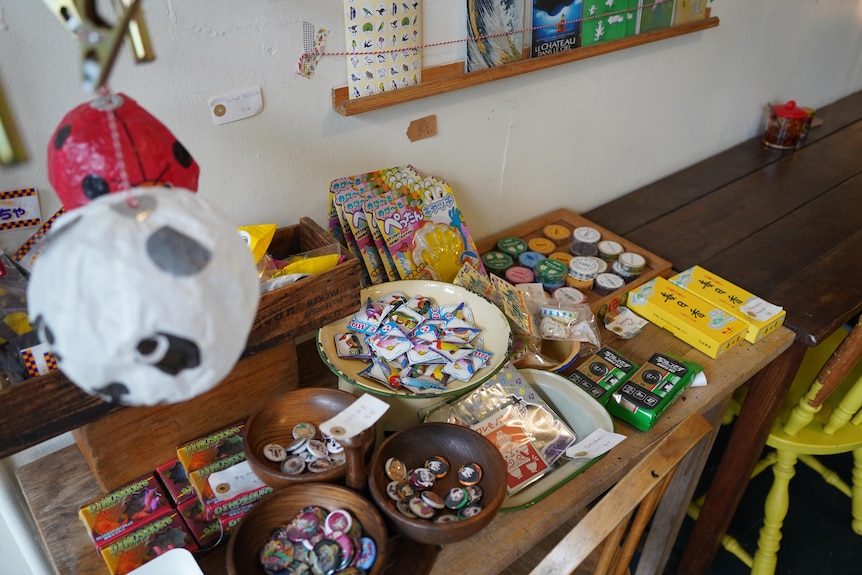 A table with miscellaneous knick knacks including badges and disposable cameras.