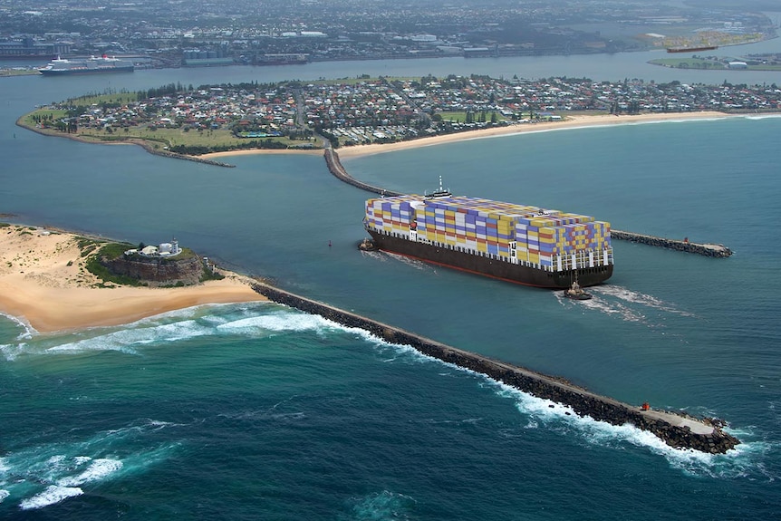 An aerial shot of a container ship entering a port