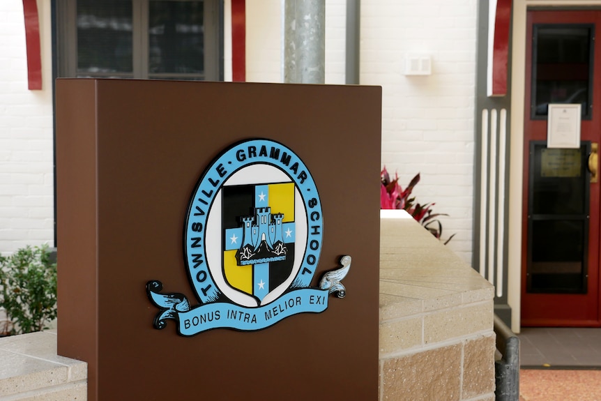 A Townsville Grammar School plaque in front of a school building