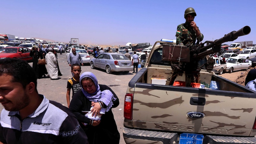 Iraqi families fleeing violence in the northern Nineveh province including its capital Mosul gather a Kurdish checkpoint.