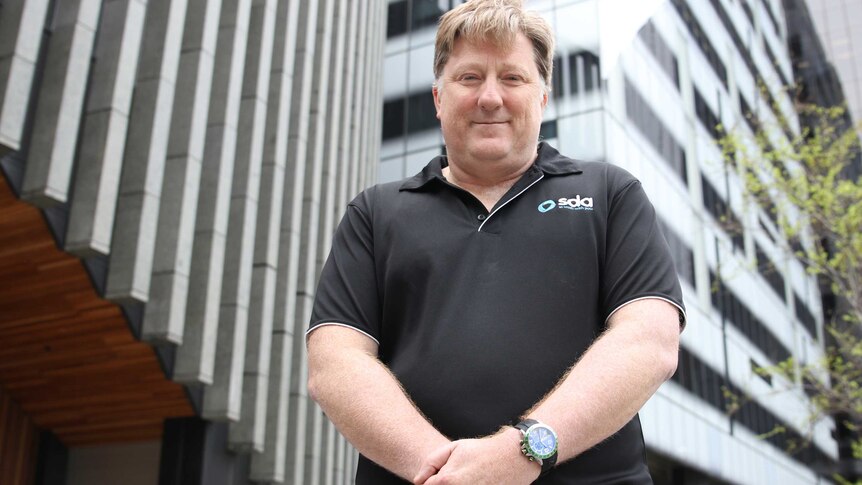 Shop, Distributive and Allied Employees' Association WA secretary Peter O'Keeffe stands with his hands clasped in a black shirt.