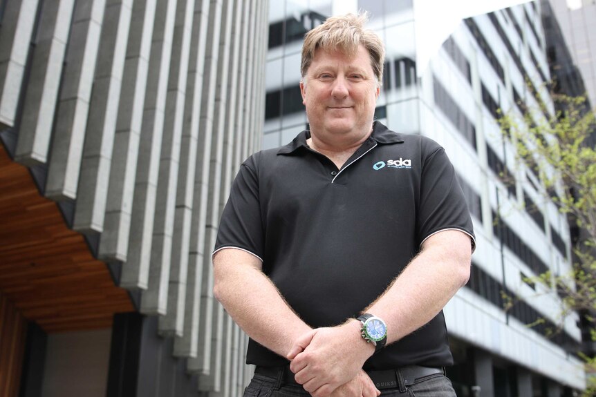 Shop, Distributive and Allied Employees' Association WA secretary Peter O'Keeffe stands with his hands clasped in a black shirt.