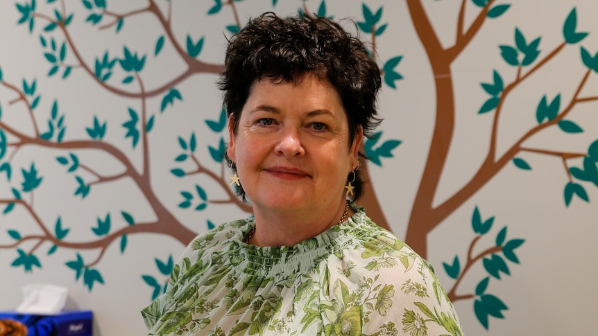 a lady with short brown hair smiles at the camera