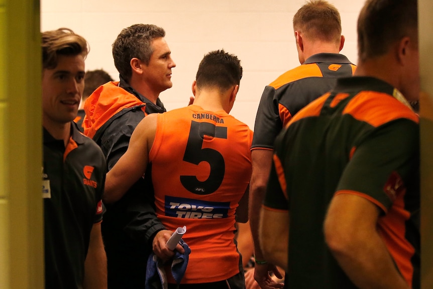 Giants coach Leon Cameron looks relaxed as he stands in the rooms with his players after a finals win.