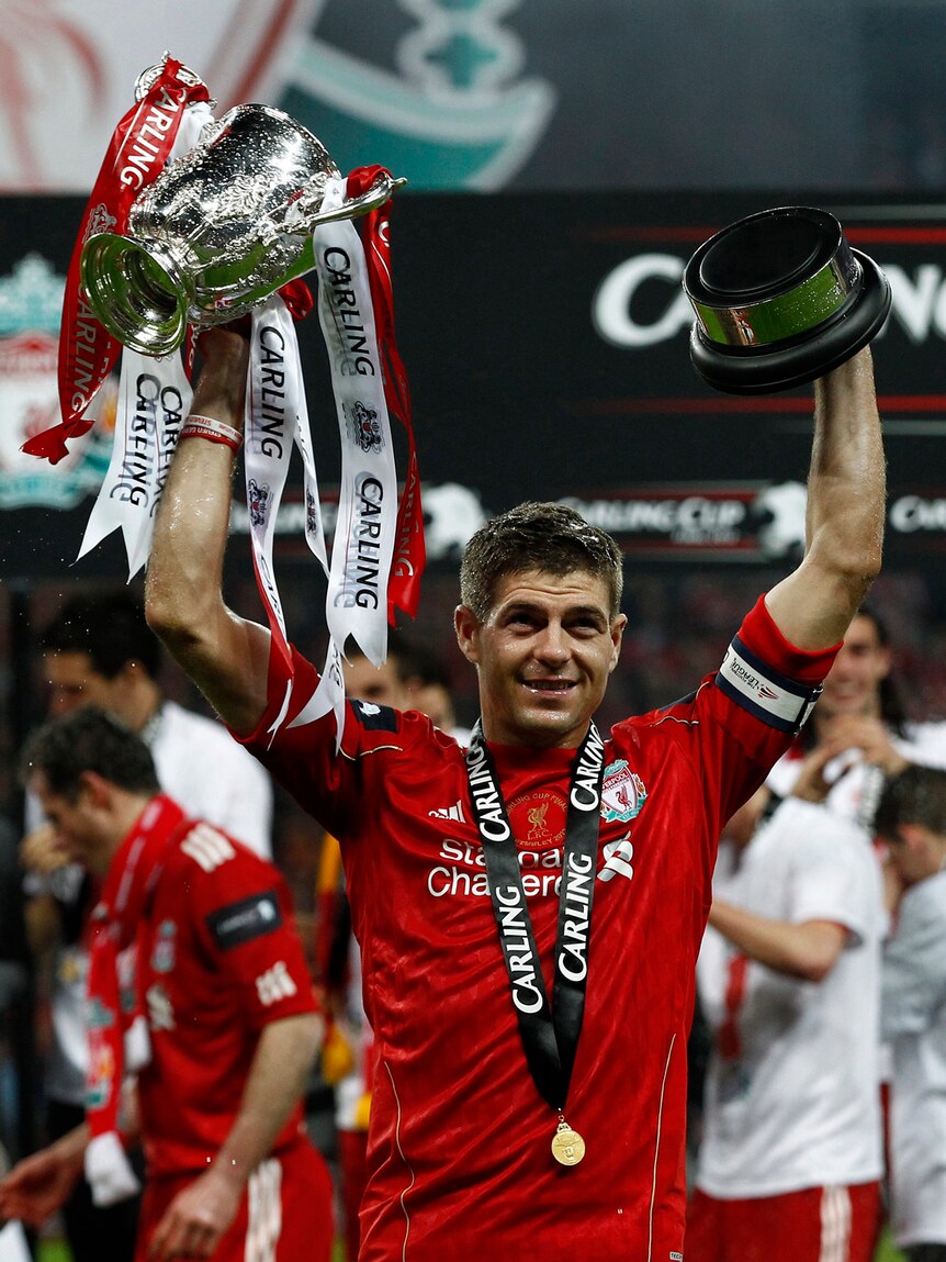 Steven Gerrard celebrates with the League Cup trophy