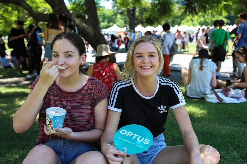 Rose Robinson (L) and Rebecca Swift find a cool spot for some ice-cream