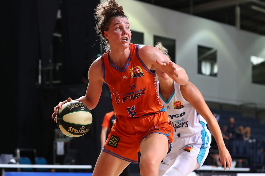 WNBL player dribbles the ball during a match with an opposition player defending her