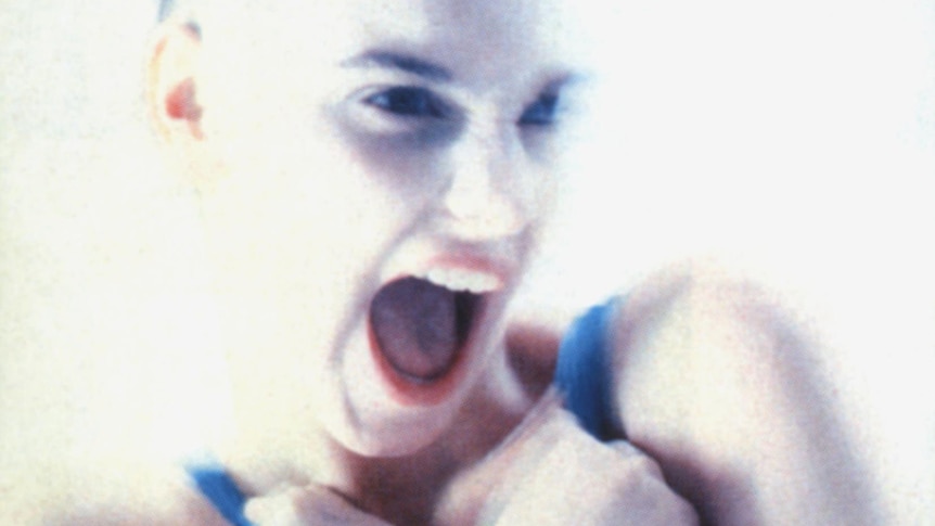 Blurred photo of Sinead O'Connor yelling from the cover of Lion and the Cobra