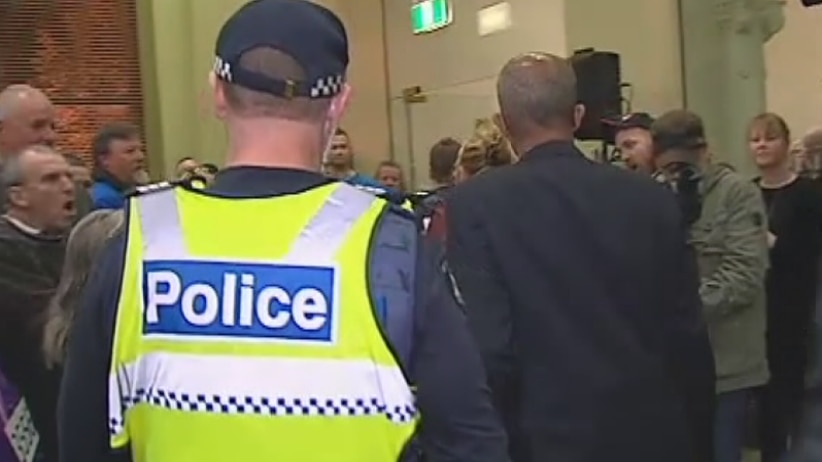 Police escort city councillors from a meeting in Bendigo, as around 150 people protest a planned mosque.