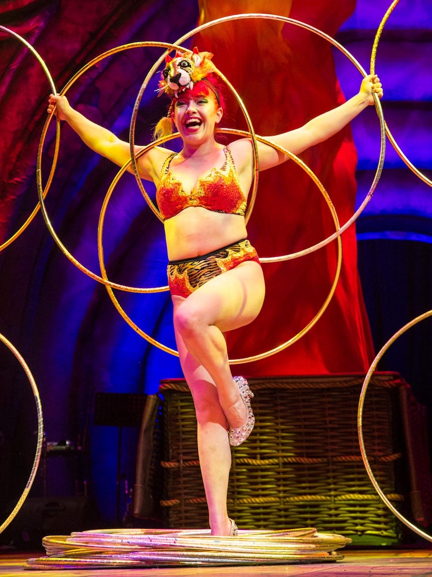 A woman holds several hula hoops into a pattern