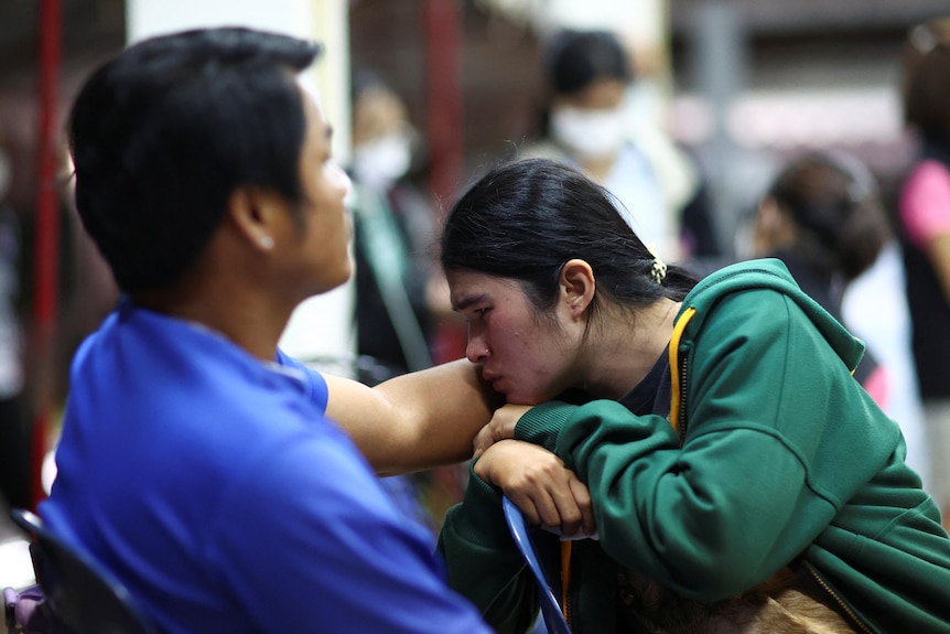 People gather outside a childcare centre in Thailand.