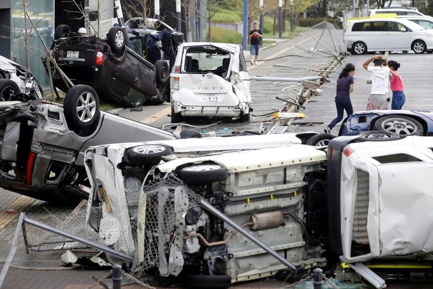 Overturned cars are seen on street following a powerful typhoon in Osaka