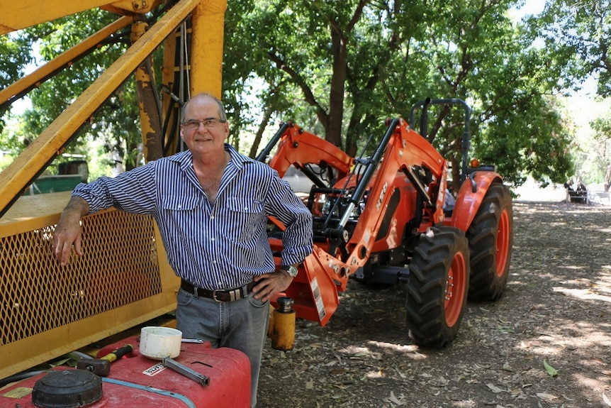 Kununurra farmer Quentin Parker standing in front of a tractor in his mango orchard.