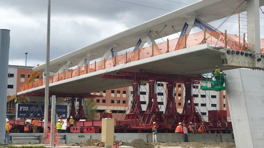 Workers construct the pedestrian bridge at Florida International University