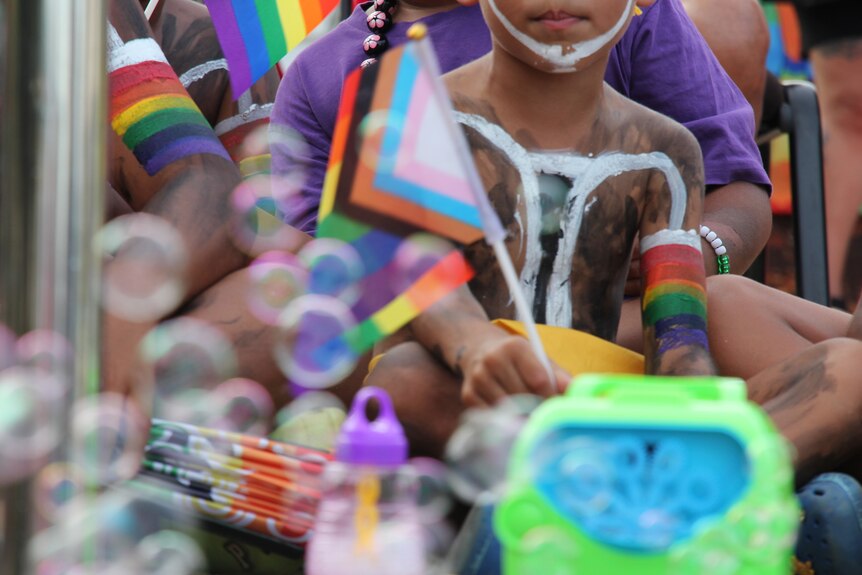 A child waves a pride flag with bubbled at Kimberley Blak Pride Festival. 