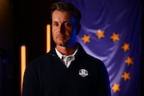 A man wearing a Team Europe jacket stands for a photo session with a European flag in the background.