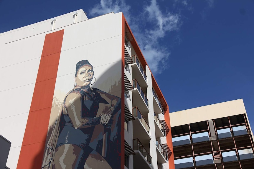 A photo of a Darwin mural emblazoned with a portrait of a Tiwi Islands sistergirl.