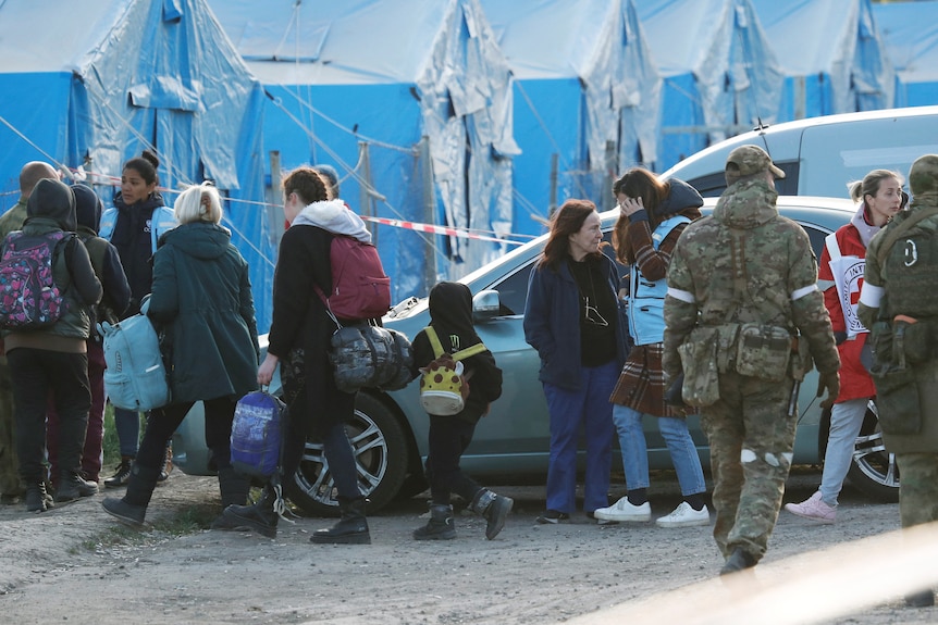 People outside blue tents.