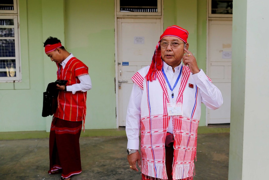 A man stands in traditional Myanmar attire