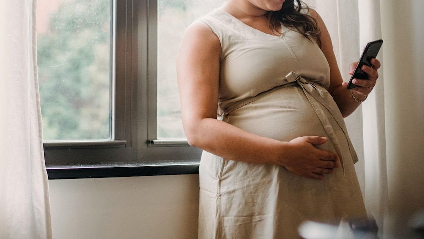 Pregnant woman looking at mobile phone