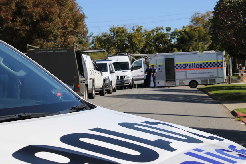 Police close street outside a home where up to five people were found dead.