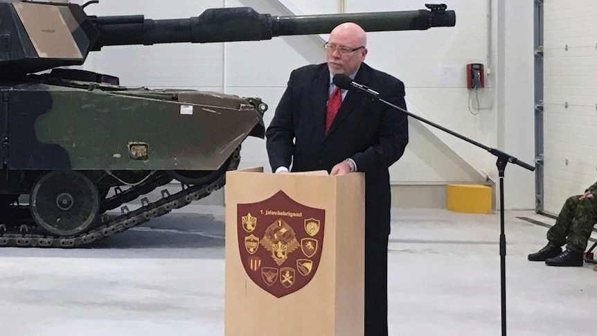 U.S. Ambassador to Estonia James D. Melville Jr addresses dignitaries in front of an U.S. Army tank