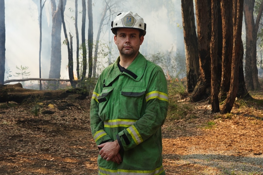 A fireman stands in front of a controlled burn