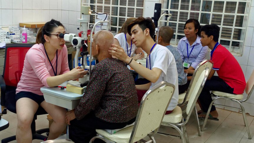Doctors examine the eyes of Cambodian patients with the help of translators.