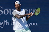 A serious-looking Nick Kyrgios brings his racquet through to complete a forehand during a match in Cincinnati.