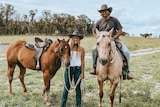 A young couple with their horses on their Granite Belt property