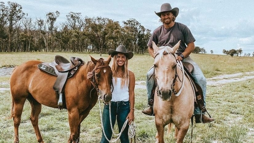 A young couple with their horses on their Granite Belt property