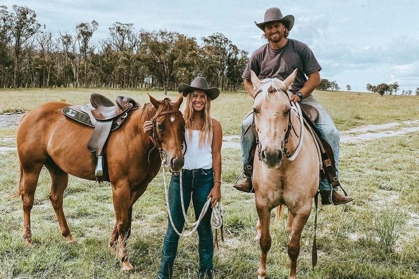 A young couple with their horses on their Granite Belt property