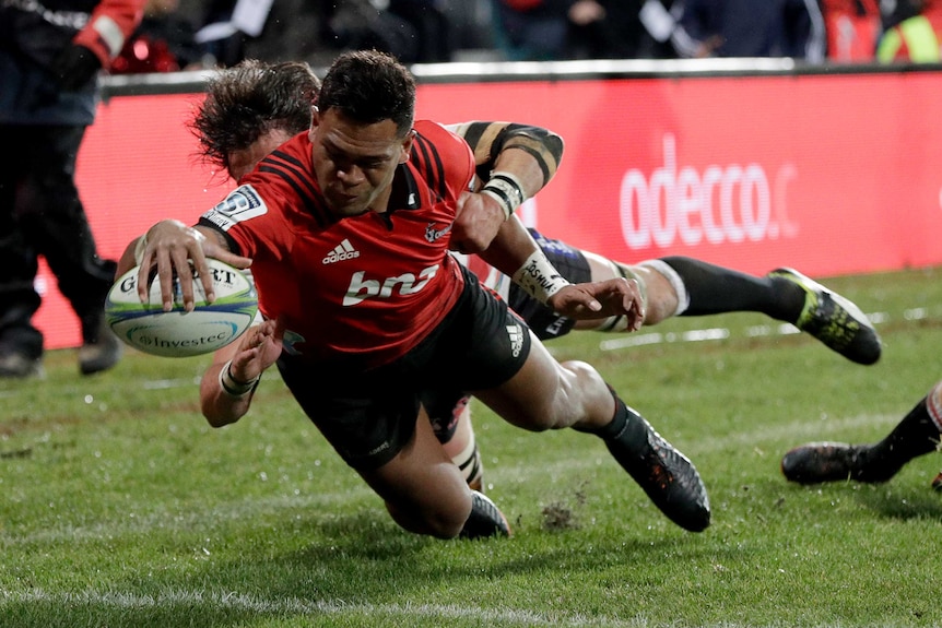 Seta Tamanivalu dives for the corner whilst being tackled with his arm outstretched with the ball.