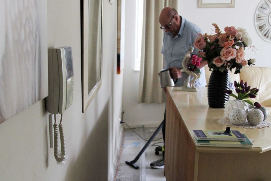 Wentworth Point resident John demonstrates how his dam contains the rainwater from a leak.