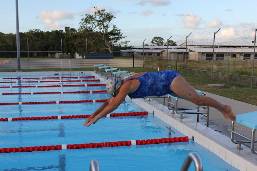 91-year-old swimmer Margaret Cunningham dives into the pool at Mackay North State High School