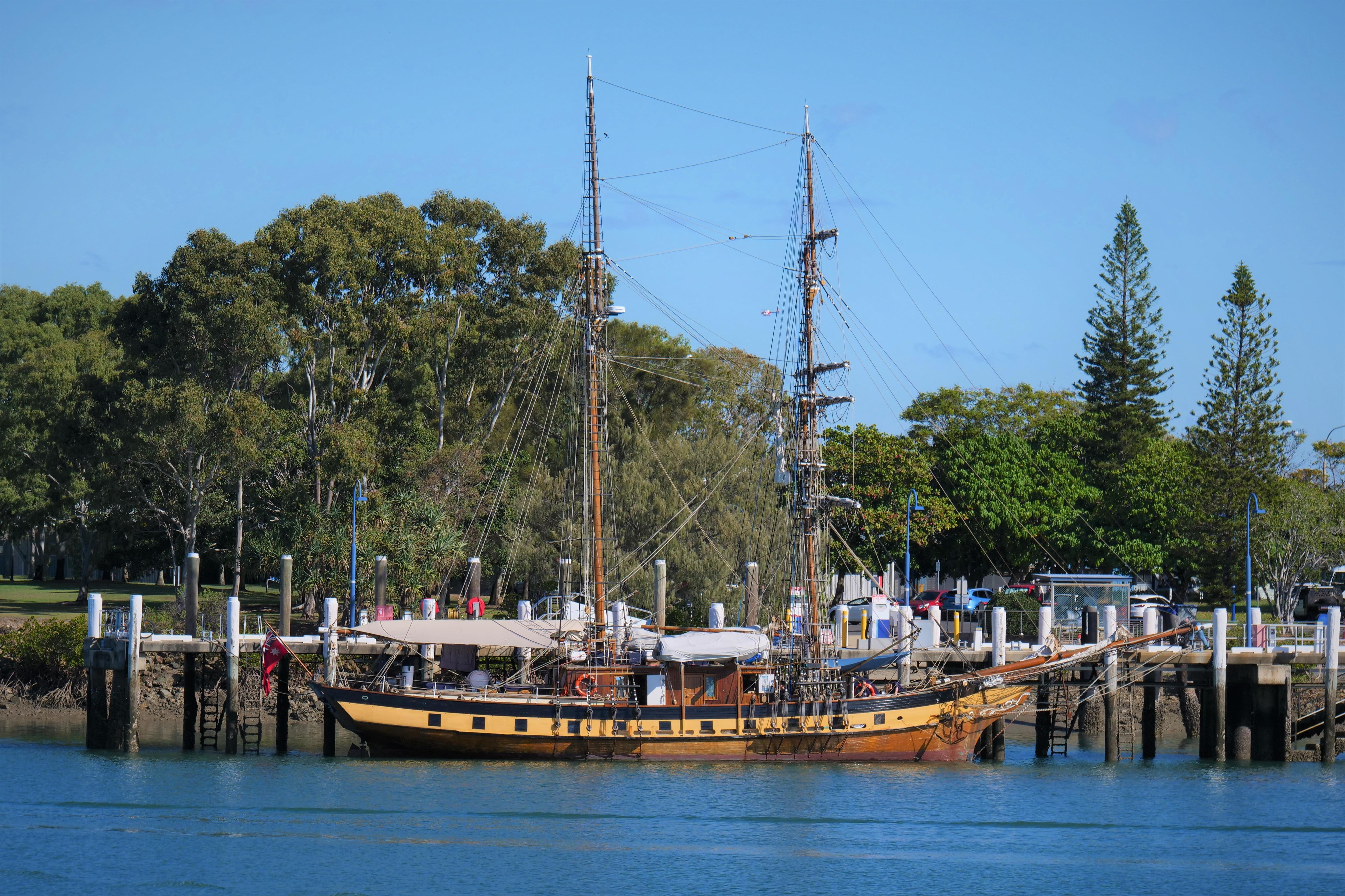A pirate looking ship on water in front of a jetty